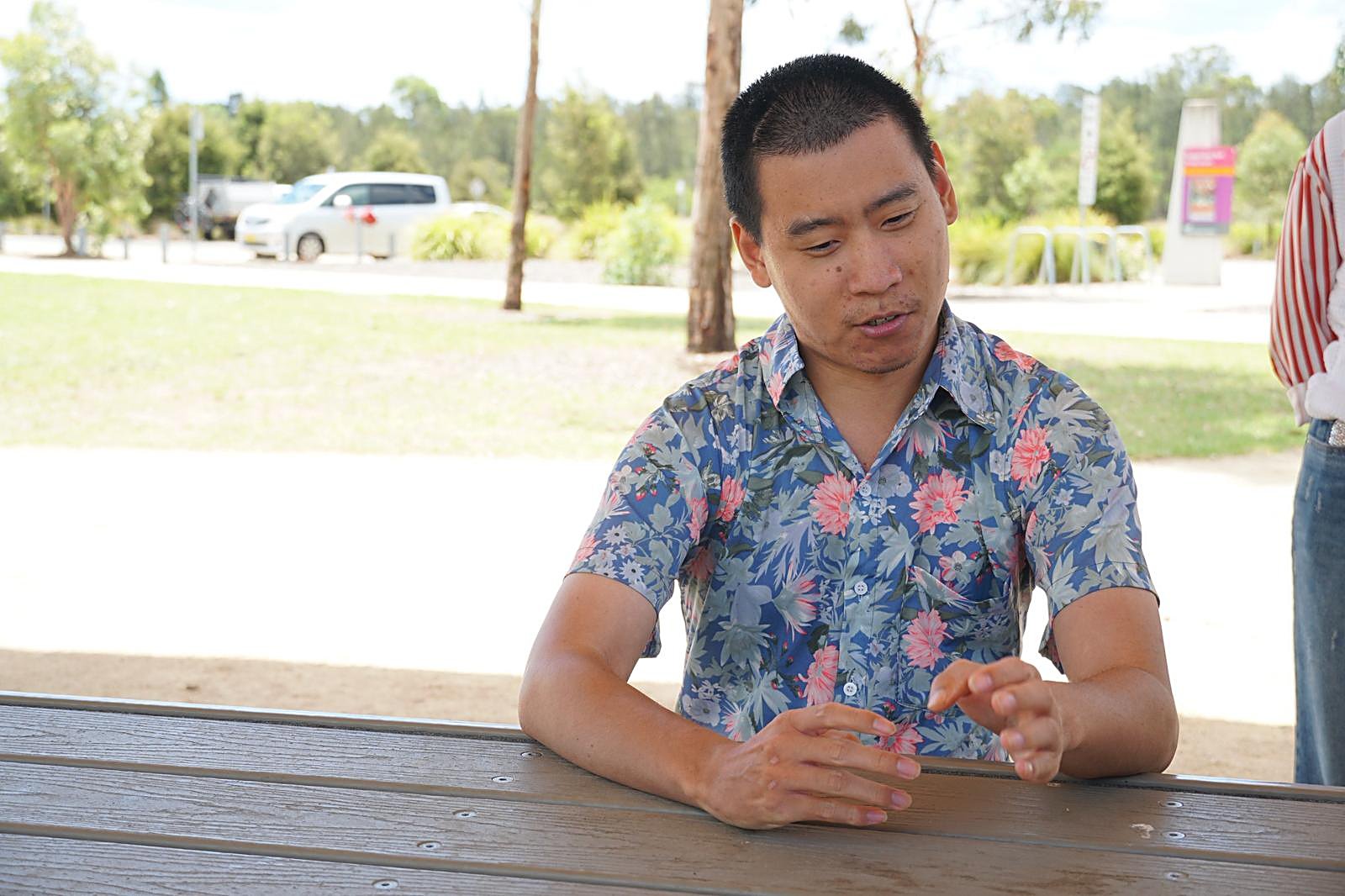 An Enable Hub participant talking at a picnic table during a community outing